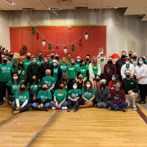 Volunteer from Starbucks posing for a group photo in the Holiday Helpers warehouse for corporate givng day
