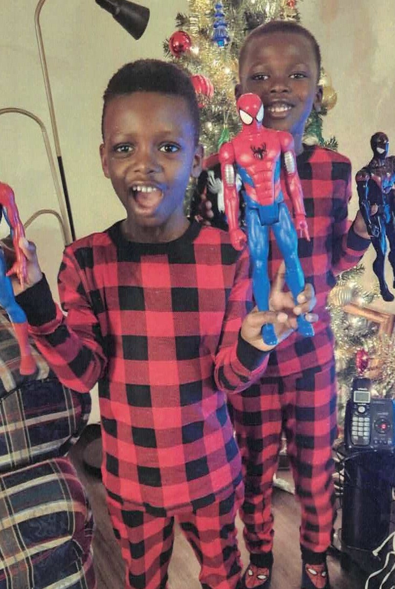 Two boys holding toys they received from Holiday Helpers at Christmas