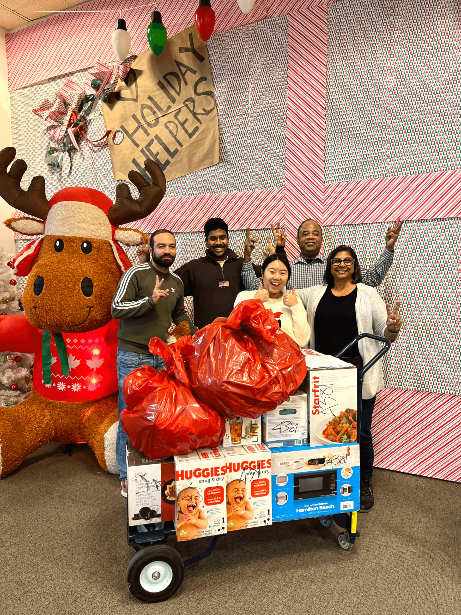 A group of colleagues volunteering in the Holiday Helpers warehouse