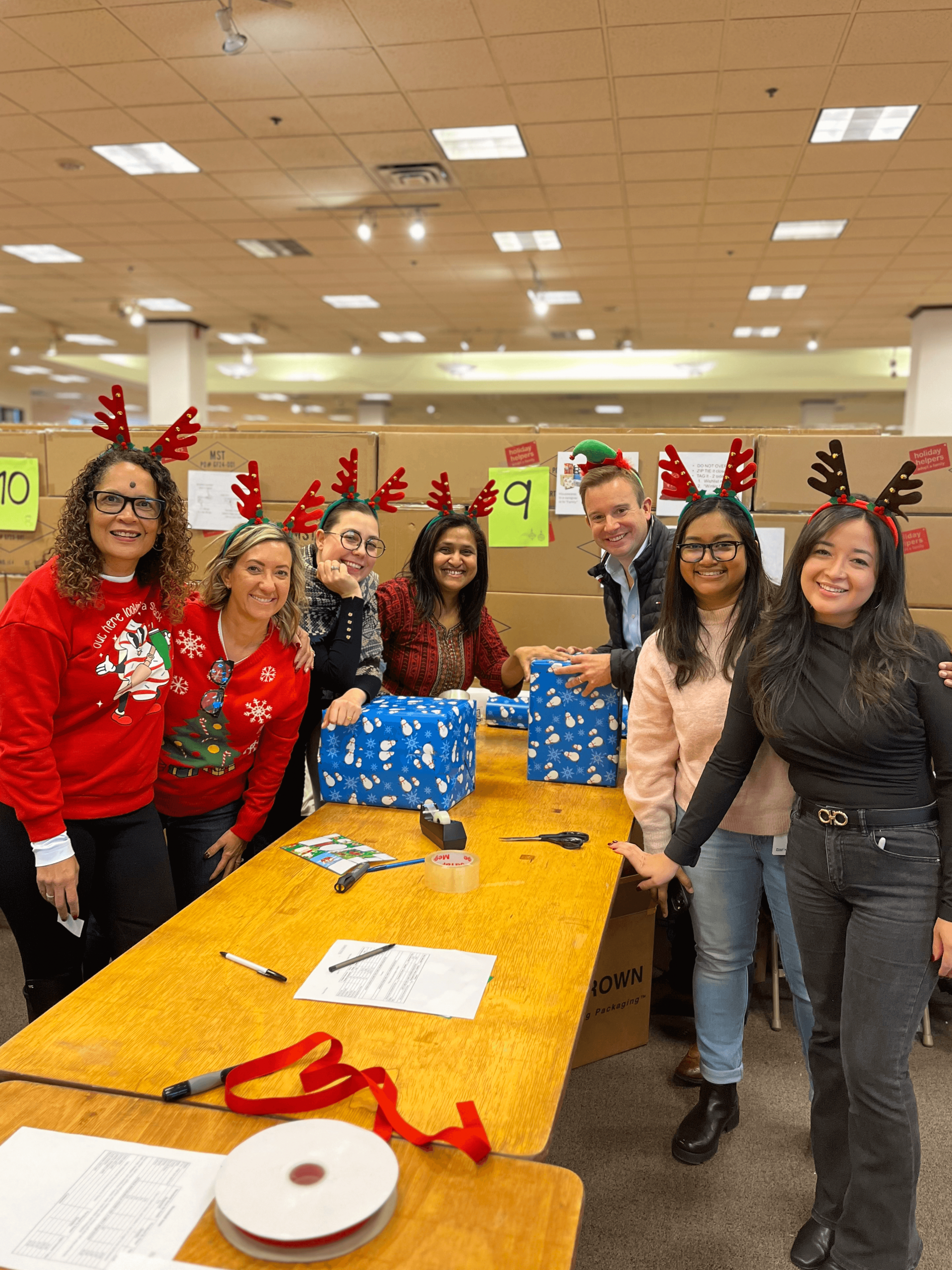 A group of employees volunteering in the Holiday Helpers warehouse