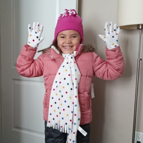 A little gril showing off her new mittens from Holiday Helpers